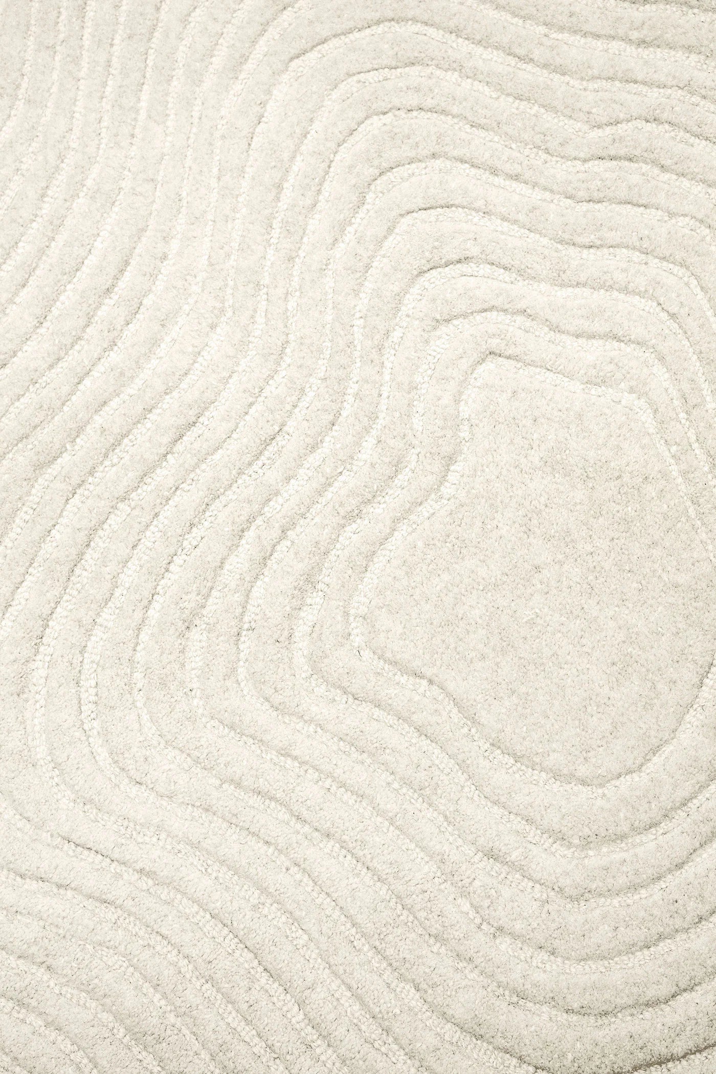 A close-up of a textured cream or off-white fabric with a wavy, topographic contour pattern.
