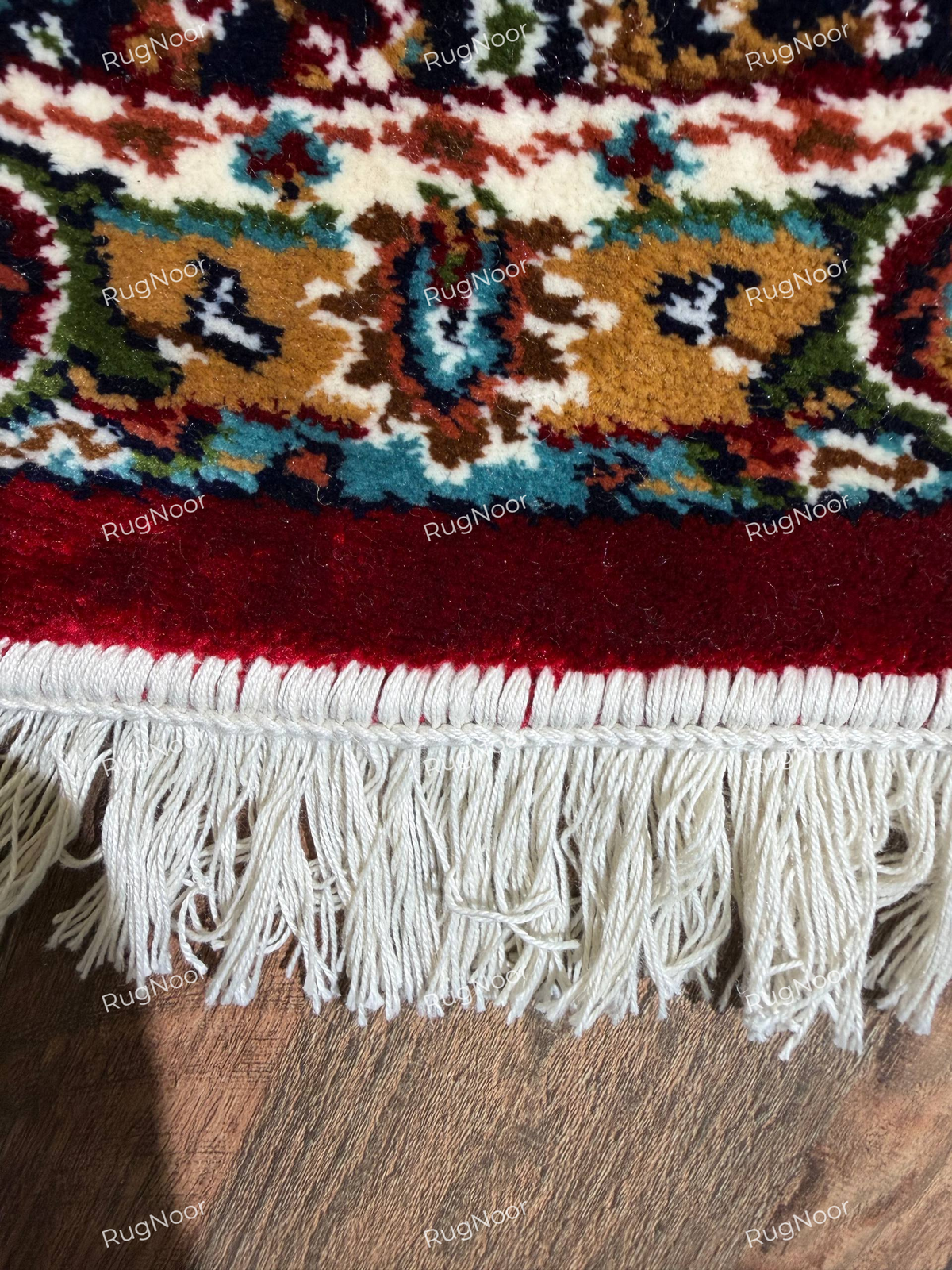 Close-up of Yaqut rug's burgundy outer edge, intricate woven border and ivory fringe - RugNoor