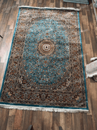 Turquoise traditional rug with ornate floral medallion, dark borders and ivory fringe - Zukhruf RugNoor