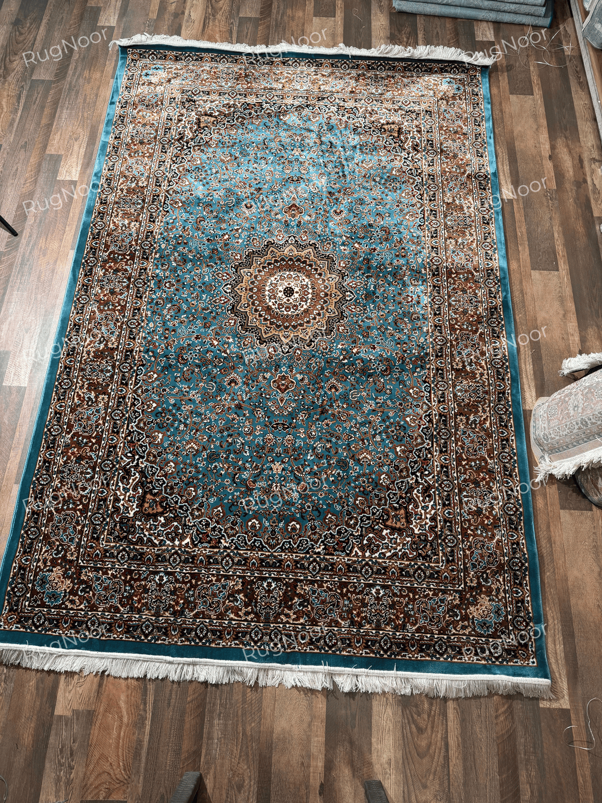 Turquoise traditional rug with ornate floral medallion, dark borders and ivory fringe - Zukhruf RugNoor