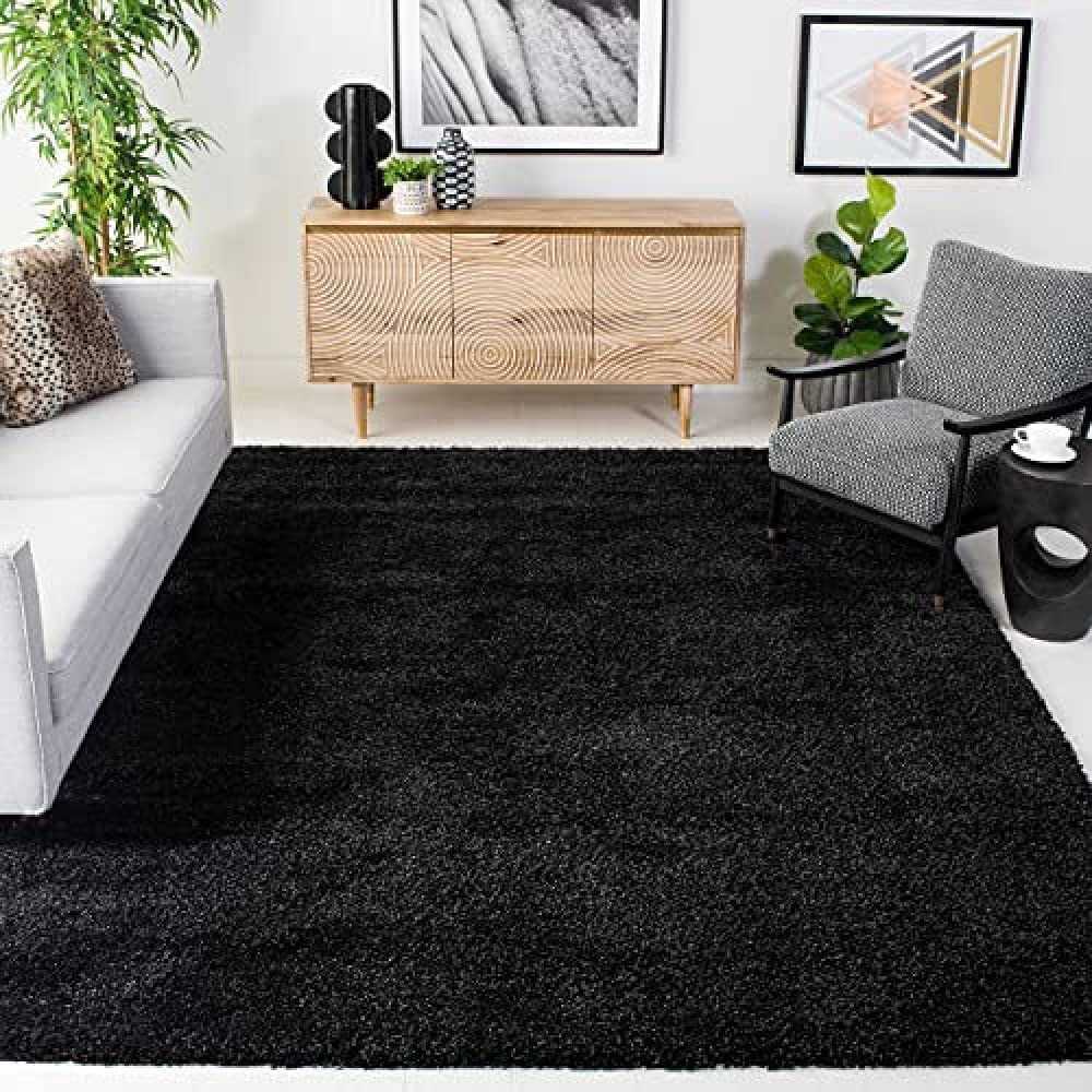 A black solid microfiber shaggy carpet placed on a floor in a room with furniture - RugNoor