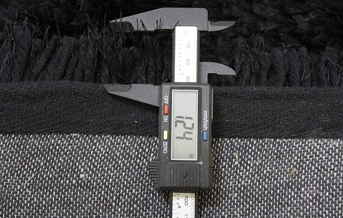 Digital caliper measuring black shag rug pile thickness - RugNoor
