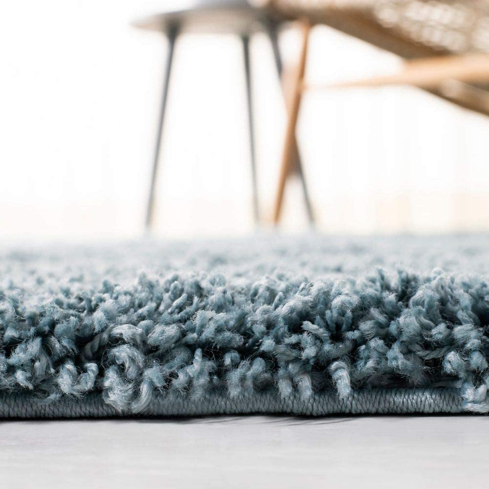 Light blue shaggy carpet edge with chair legs above - RugNoor