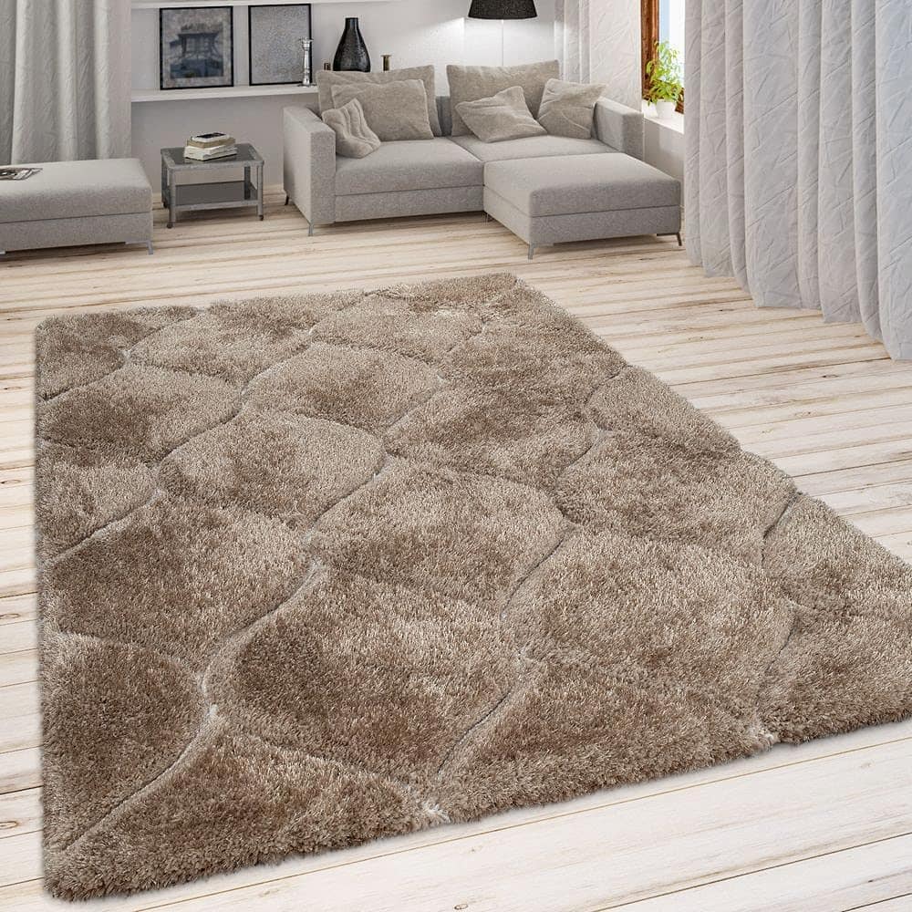 A RugNoor's brown microfiber and silk shaggy rug with an Ogee trellis pattern, placed on a wooden floor in a furnished room.