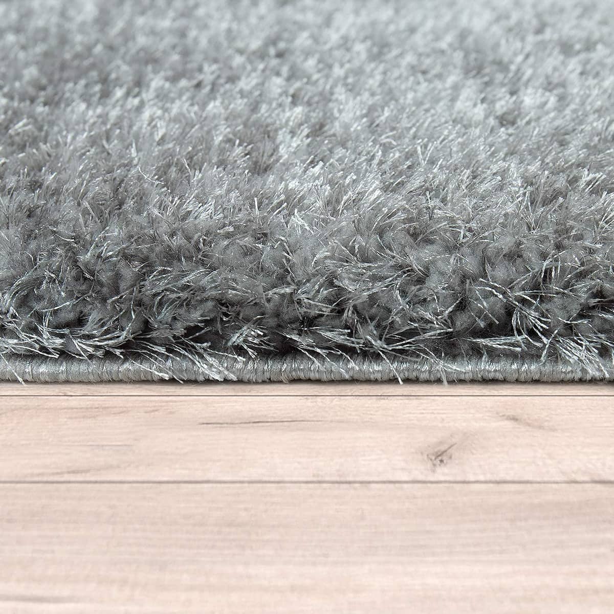 Ground-level shot of RugNoor's dark grey rug edge on a hardwood surface