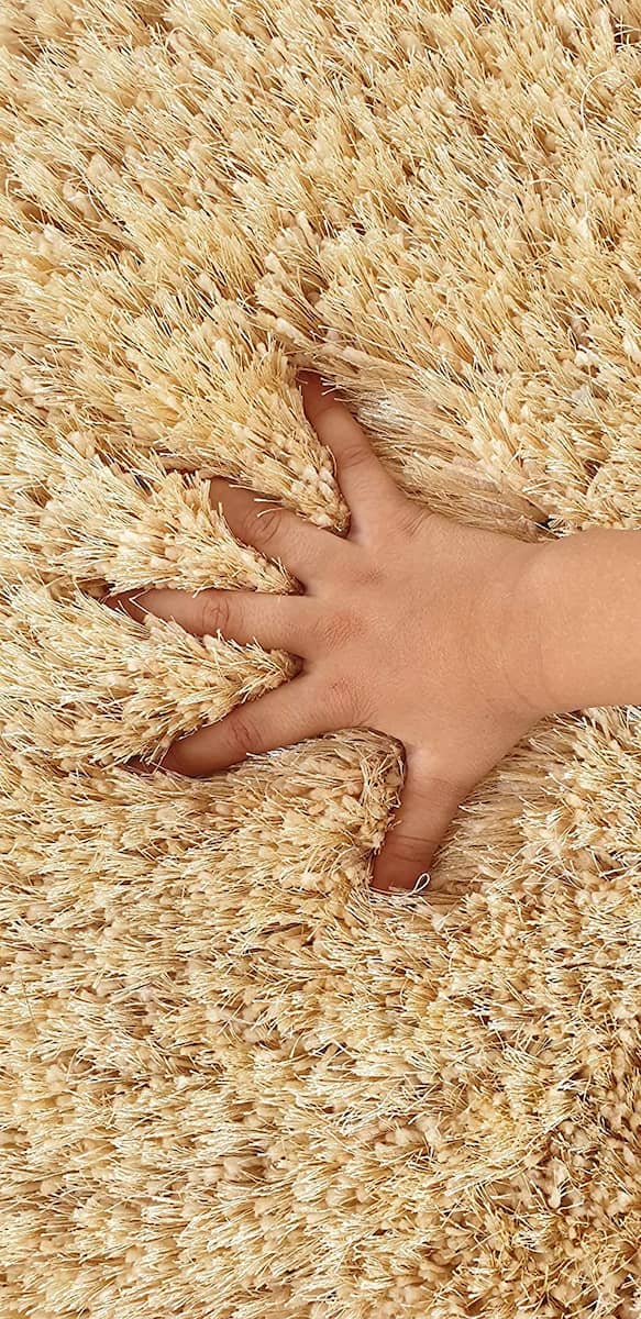 Hand sinking into thick cream shag rug pile - RugNoor