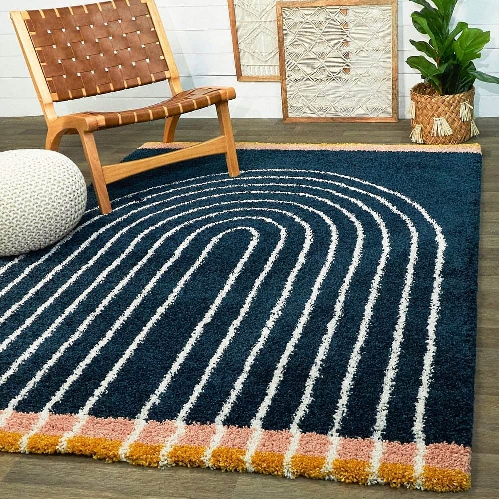 Navy blue swirl modern pattern shag rug with pink orange border in living room, RugNoor fluffy carpet