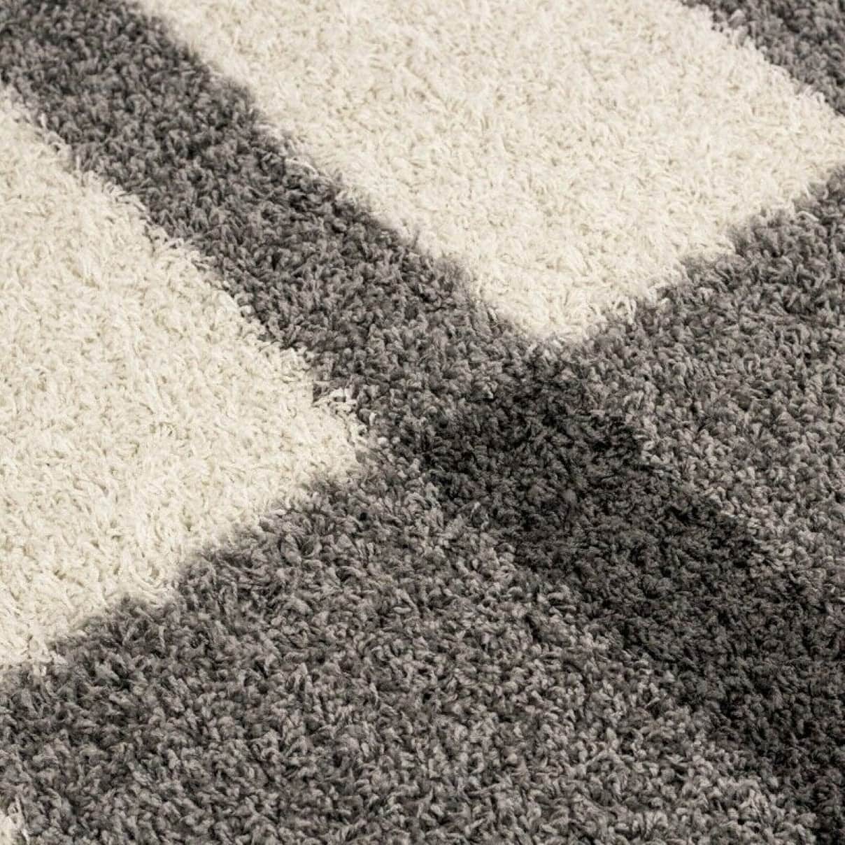 RugNoor carpet showing a bold X-shaped split between grey and white shaggy carpet