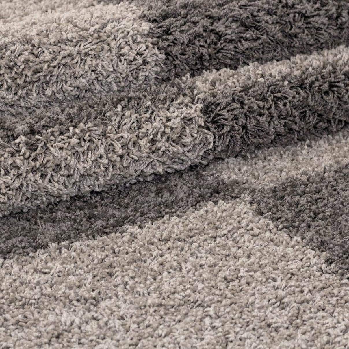 Folded corner of a design brown shaggy rug showing pile plushness