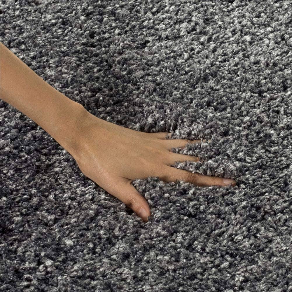 Hand touching soft dark grey shag rug pile - RugNoor