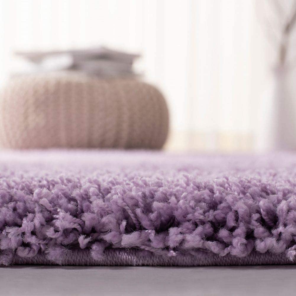 Lilac shag rug edge close-up with blanket in background - RugNoor