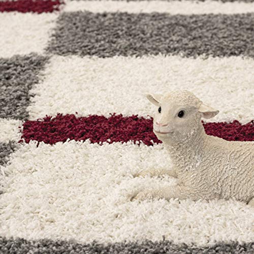 Toy lamb resting on a striped shag rug in white, maroon and grey