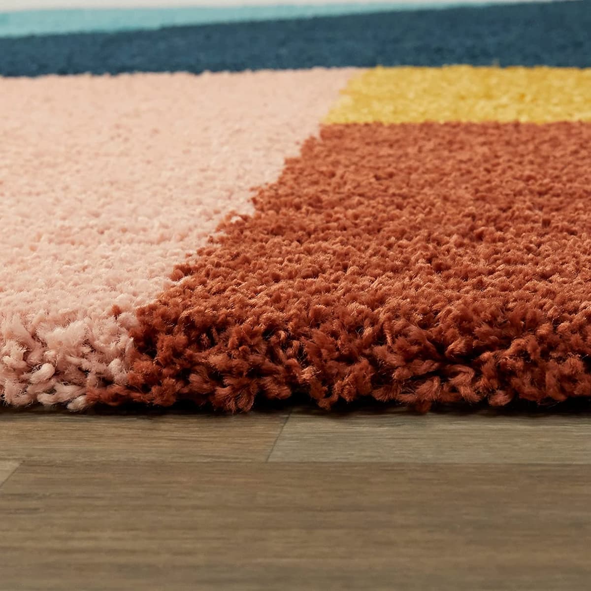 RugNoor close-up rust pink teal mustard shag rug pile texture, soft fluffy carpet