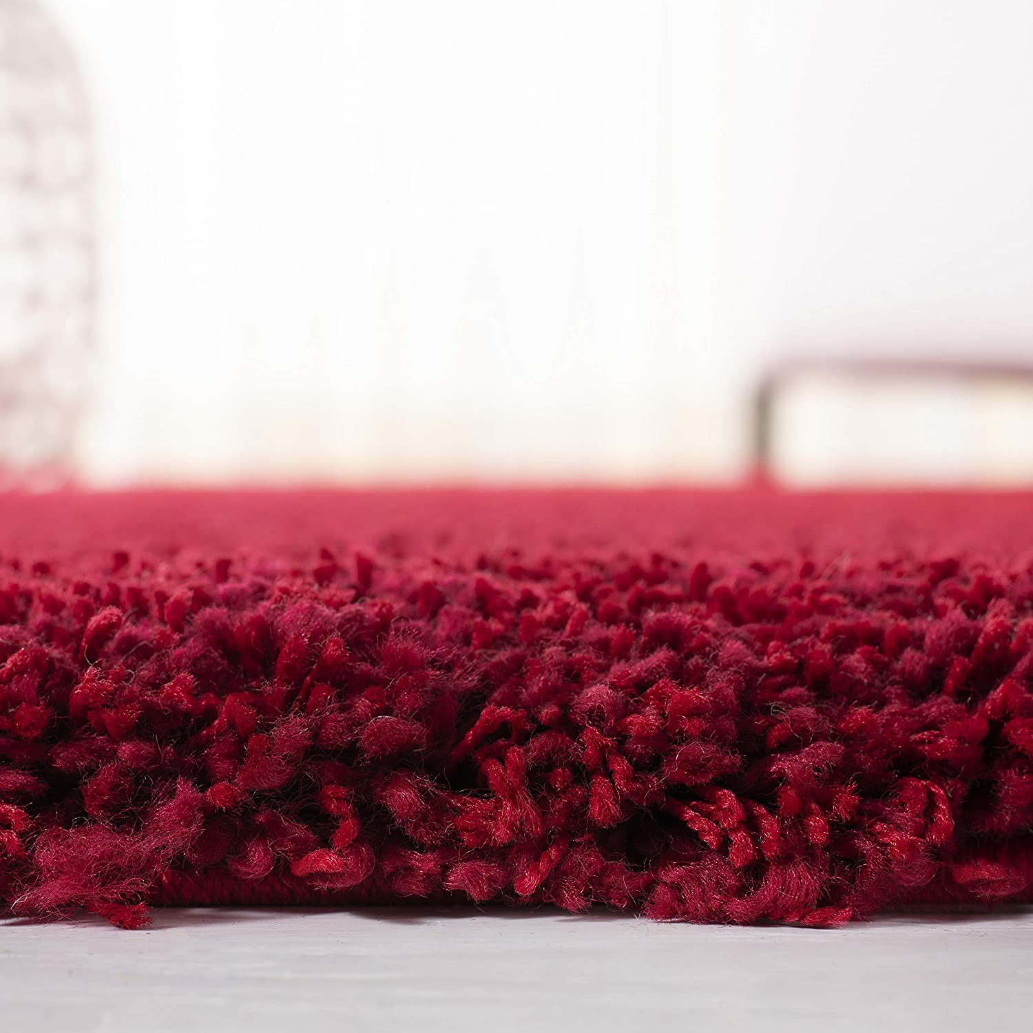 rose red shag rug edge close-up with plant in background - RugNoor