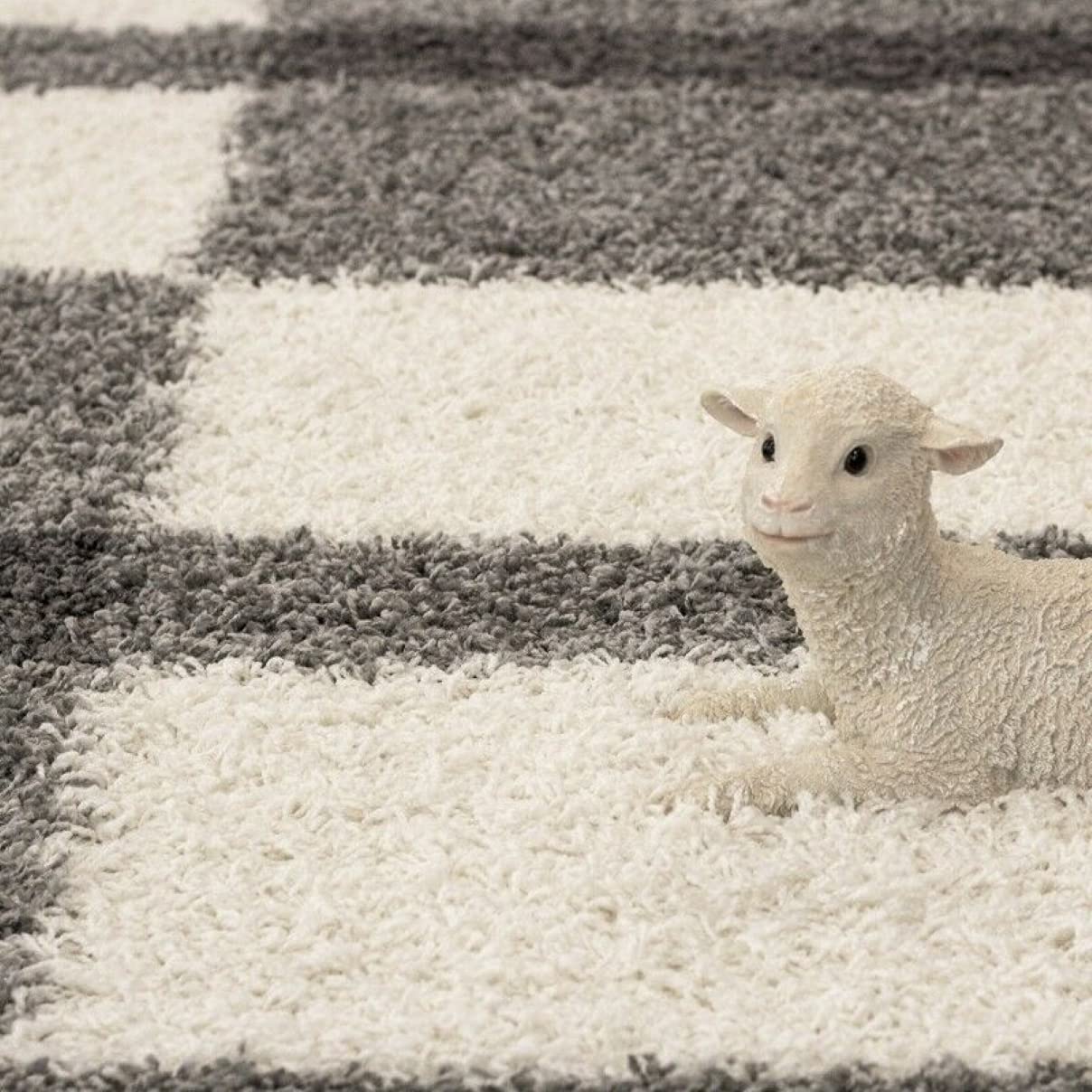 Toy lamb sitting on a RugNoor's checkered grey and white shag rug