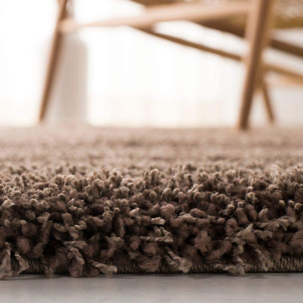 Taupe shag rug edge close-up with wooden chair legs - RugNoor