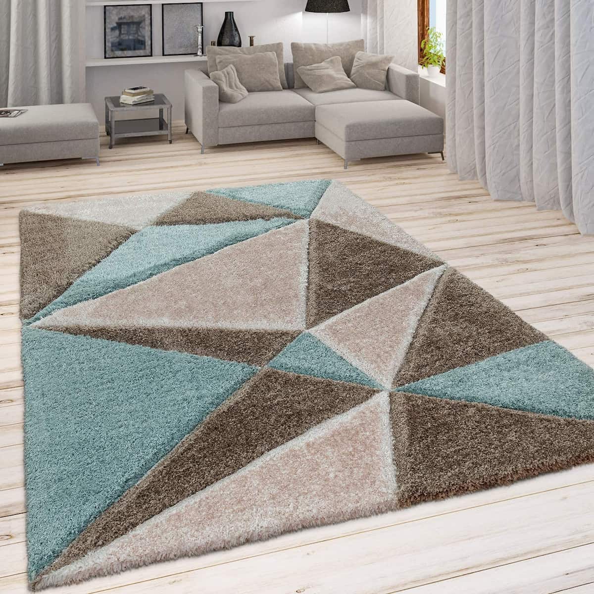 A RugNoor geometric diamond-shaped design rug in brown, grey, and aqua colors, placed on a wooden floor in a living room setting.