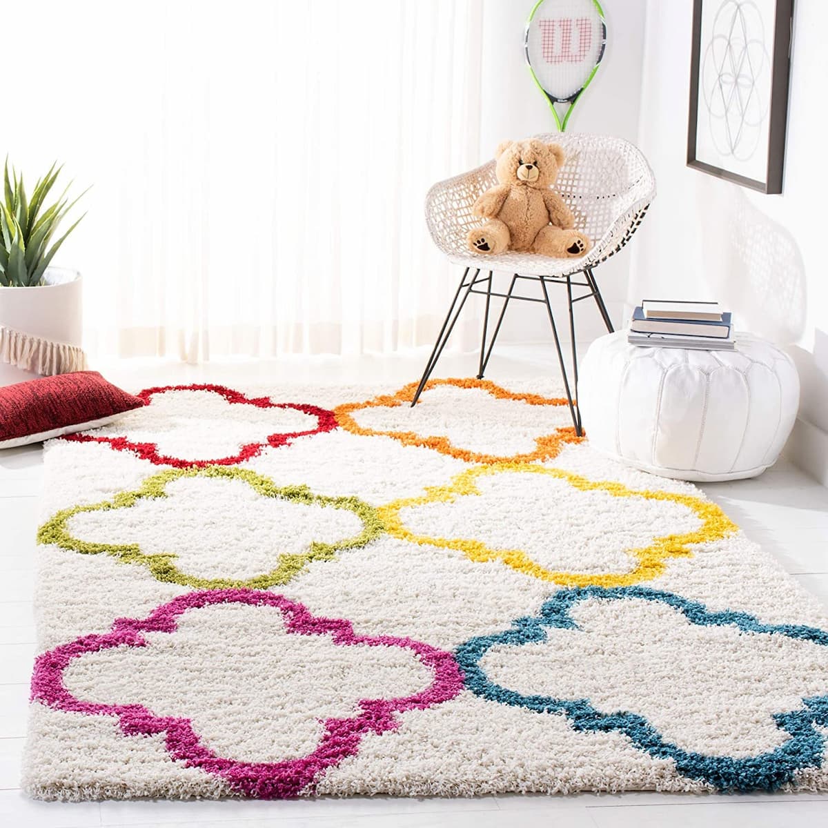 RugNoor's colorful geometric patterned microfiber shaggy rug in a room with a white chair, a teddy bear, and house plants.